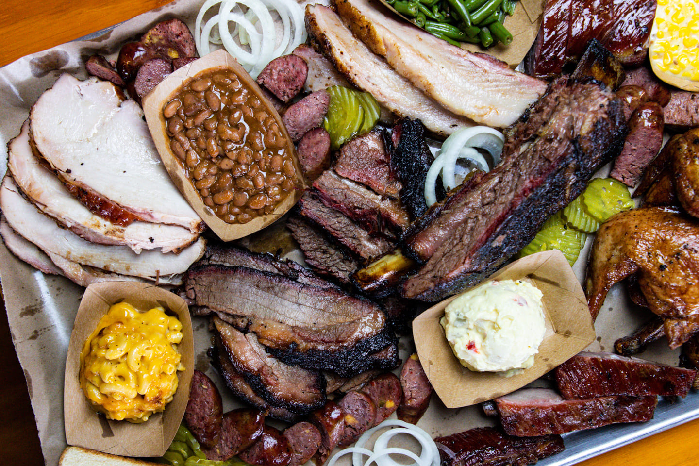 A Texas Style Charcuterie board made of brisket, sausage, chicken, turkey, mac & cheese, & mashed potatoes.