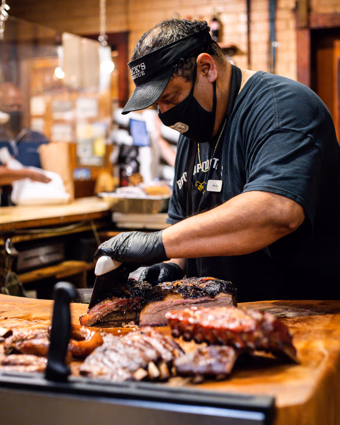 Black's BBQ employee slicing brisket for a customer