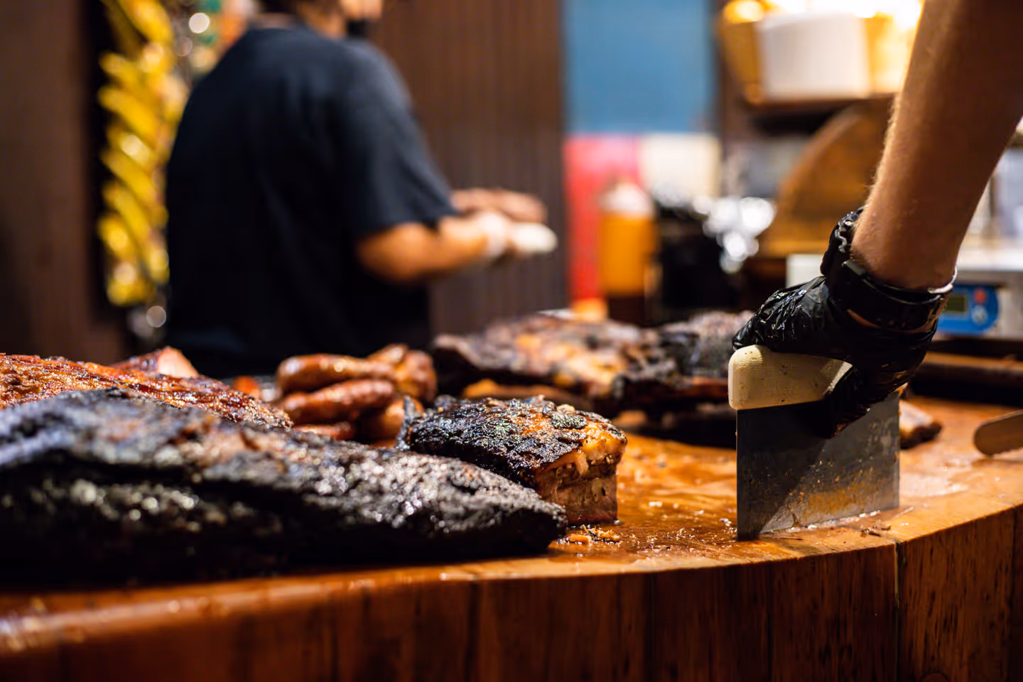 Black's BBQ Employee celebrating with a beer & brisket