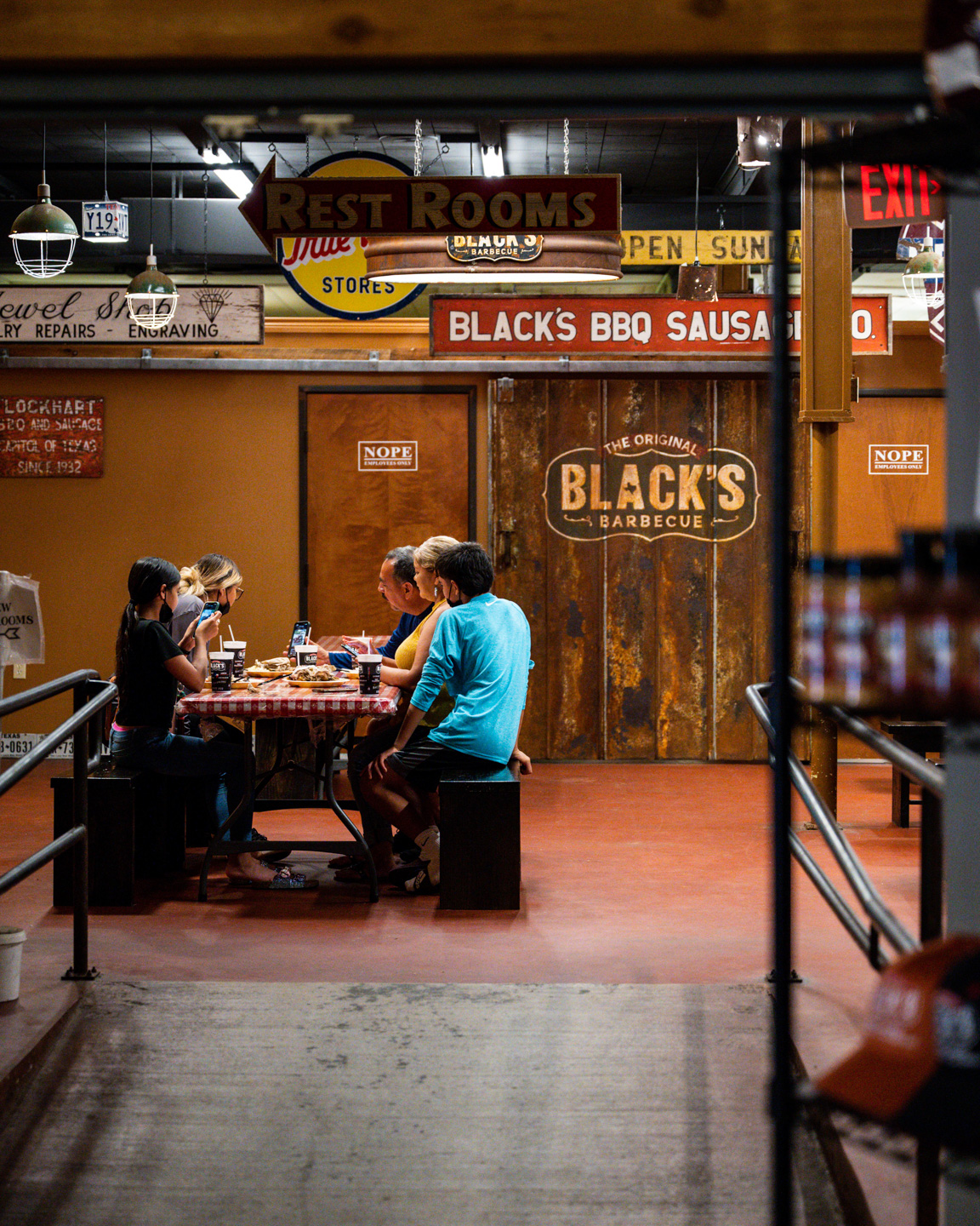 Black's BBQ Employee celebrating with a beer & brisket