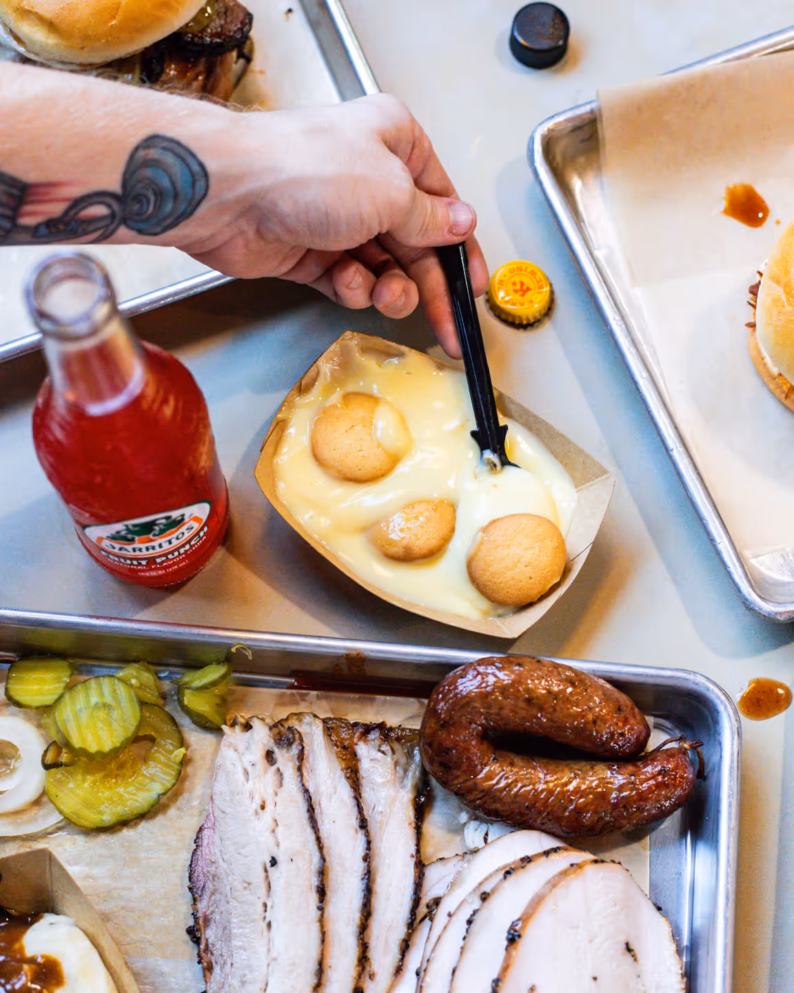 Black's BBQ Employee celebrating with a beer & brisket