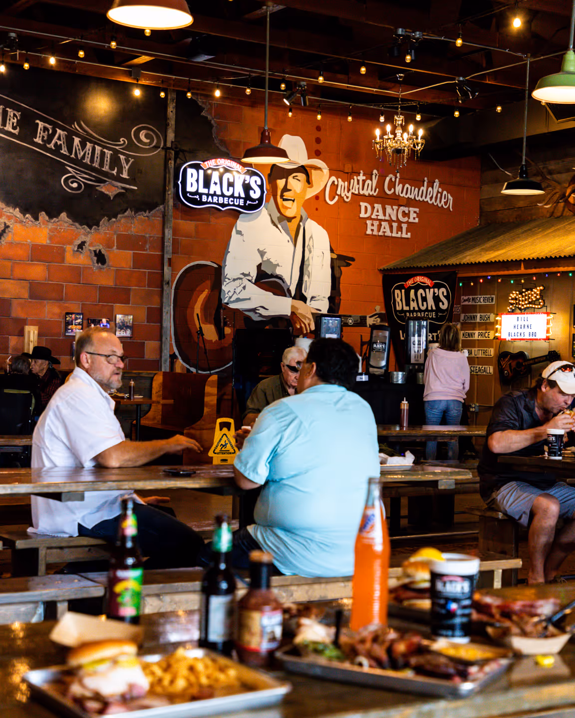 Black's BBQ Employee celebrating with a beer & brisket